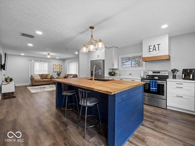 kitchen featuring visible vents, electric stove, dark wood-style floors, wooden counters, and a sink