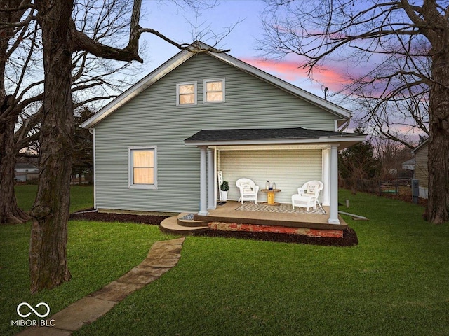 rear view of property featuring a lawn