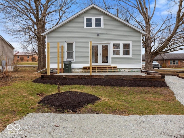 bungalow-style house featuring entry steps, a front yard, and french doors