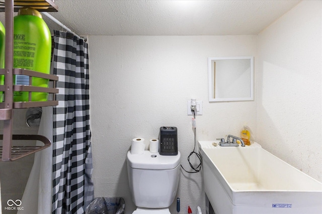 full bath featuring a textured wall, a shower with shower curtain, toilet, a textured ceiling, and vanity