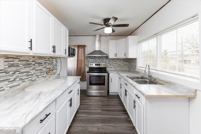 kitchen featuring stainless steel range with electric cooktop, a sink, wall chimney range hood, white cabinets, and black microwave