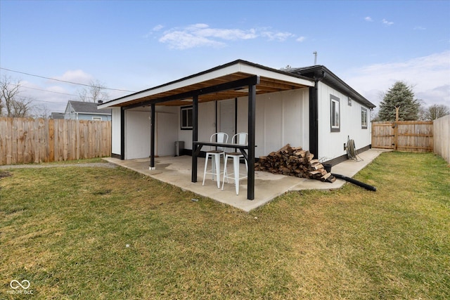 back of property with a patio, a lawn, and a fenced backyard