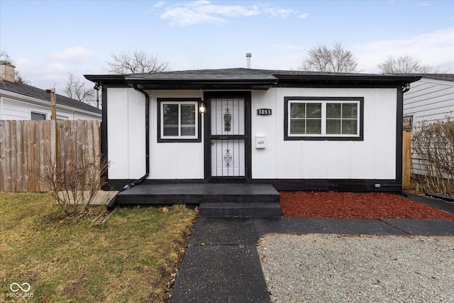 bungalow-style house with fence