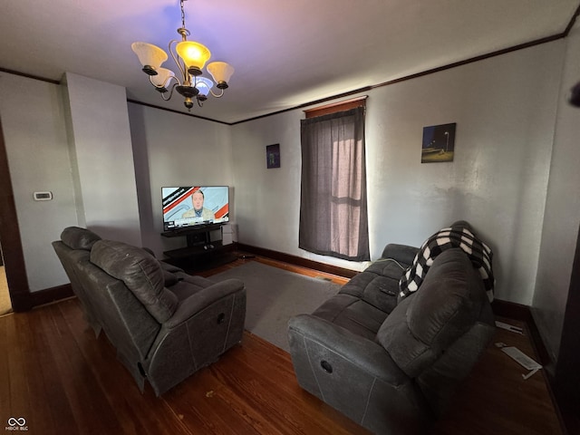 living area with crown molding, wood finished floors, and an inviting chandelier