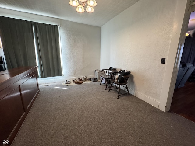 misc room with an inviting chandelier, carpet flooring, and a textured wall