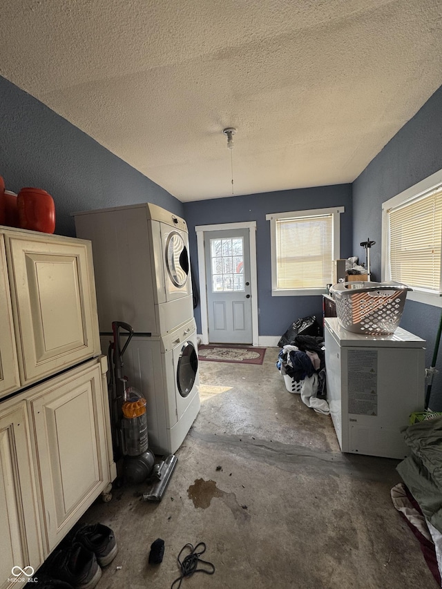 laundry area featuring stacked washer and clothes dryer and a textured ceiling