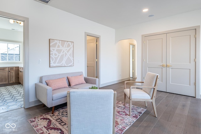 living area featuring arched walkways, recessed lighting, wood finished floors, and baseboards