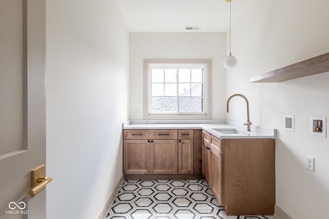 interior space with washer hookup, a sink, visible vents, cabinet space, and light floors