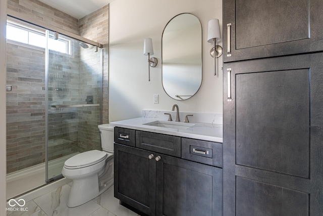 full bathroom featuring toilet, marble finish floor, vanity, and a stall shower