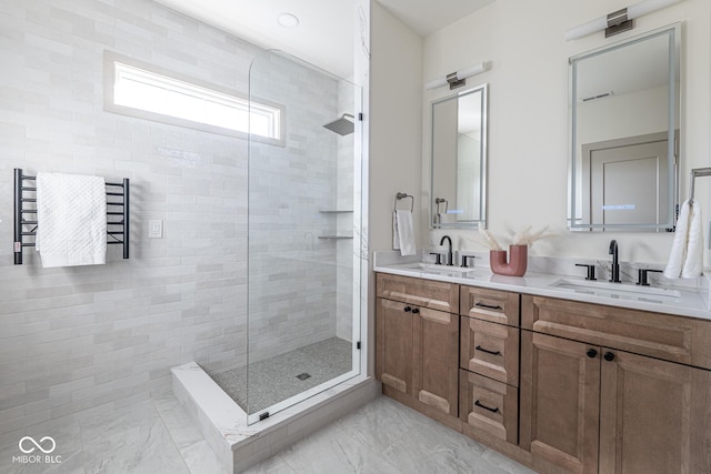 full bathroom featuring double vanity, tiled shower, and a sink