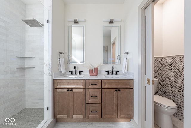 bathroom with a sink, a shower stall, and toilet