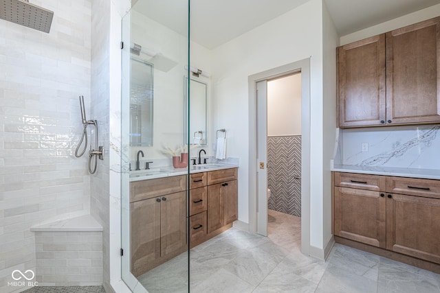 full bathroom featuring marble finish floor, a walk in shower, decorative backsplash, and vanity