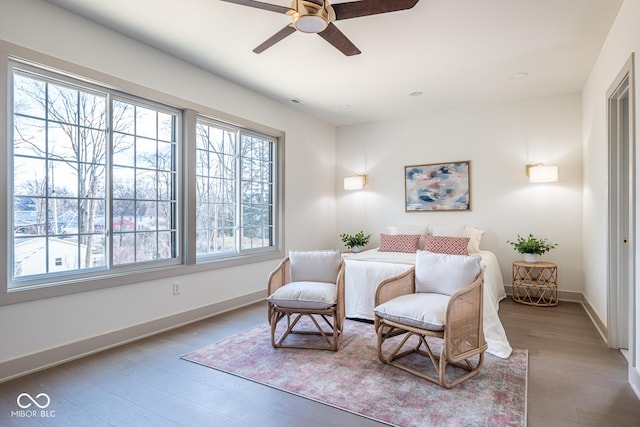 sitting room with a ceiling fan, visible vents, baseboards, and wood finished floors