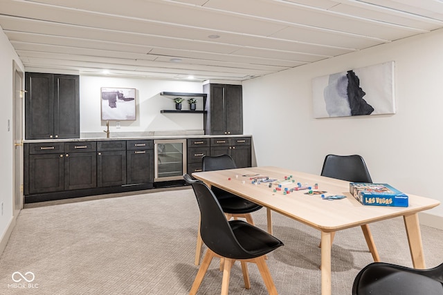 office space featuring wet bar, beverage cooler, light colored carpet, and a sink