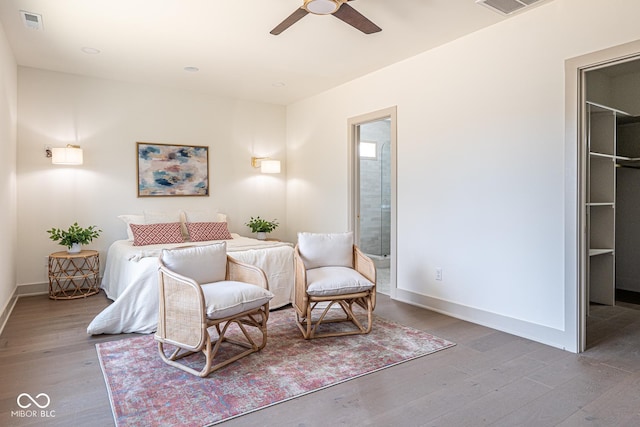 bedroom featuring ensuite bath, baseboards, and wood finished floors