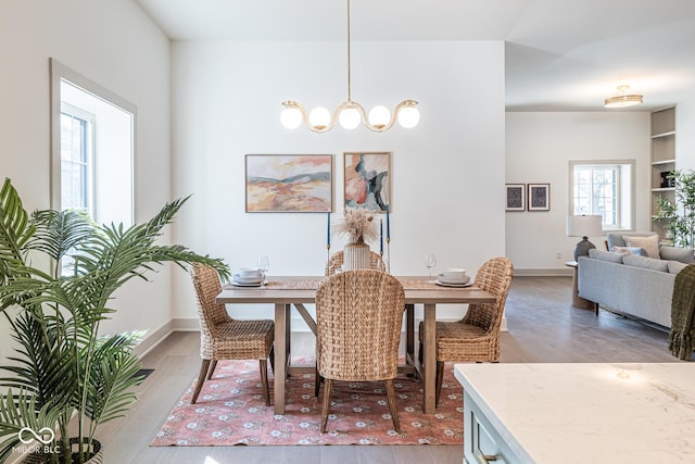 dining space with light wood-type flooring and baseboards