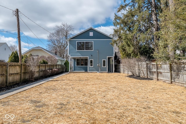 back of house with a fenced backyard