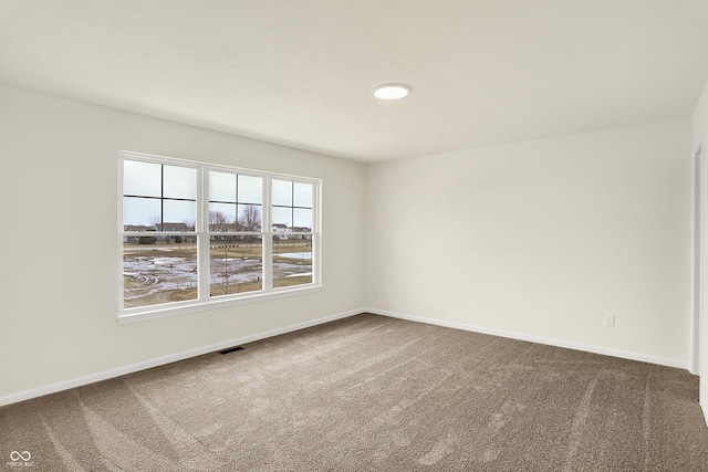 carpeted empty room featuring visible vents and baseboards