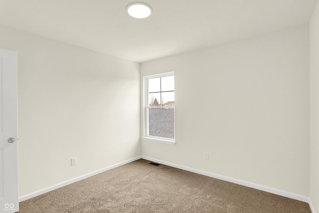 carpeted spare room featuring baseboards and visible vents