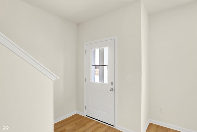 doorway to outside with light wood-type flooring and baseboards