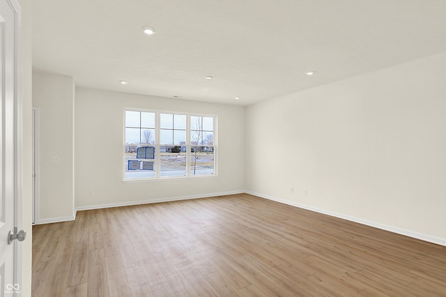 empty room with light wood-style floors, baseboards, and recessed lighting