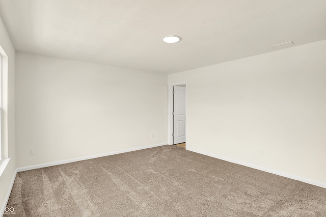 unfurnished room with carpet flooring and baseboards