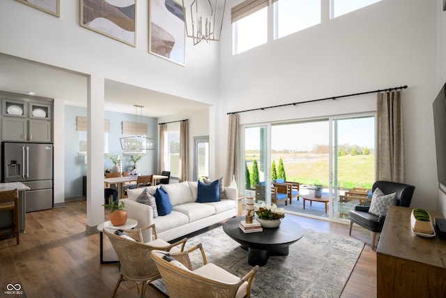 living room featuring plenty of natural light, a notable chandelier, and wood finished floors