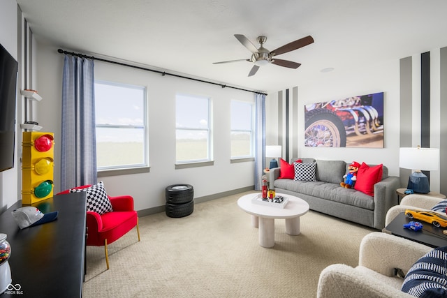 carpeted living room with a ceiling fan and baseboards