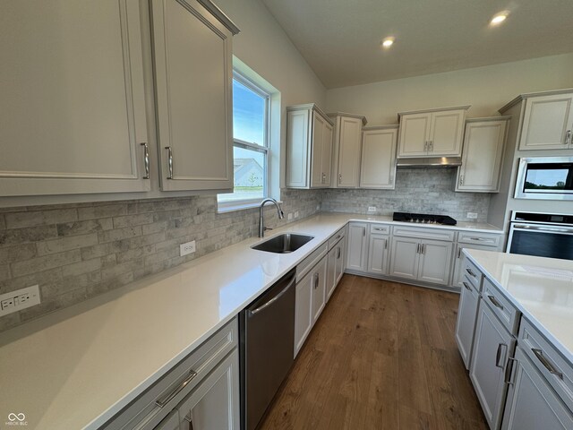 15871 Vitalize Run, Fishers, IN 46040 - kitchen with stainless steel appliances, a sink, light countertops, dark wood-type flooring, and decorative backsplash