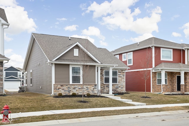 view of front of home featuring stone siding, a shingled roof, and a front yard