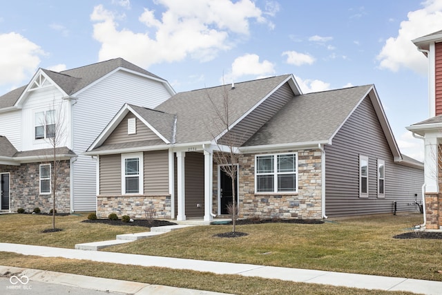 view of front of home featuring stone siding, a shingled roof, and a front yard