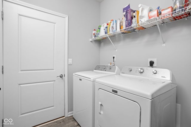 laundry area with laundry area, independent washer and dryer, and wood finished floors