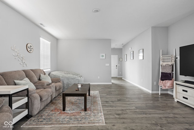 living room featuring dark wood-style floors, visible vents, and baseboards