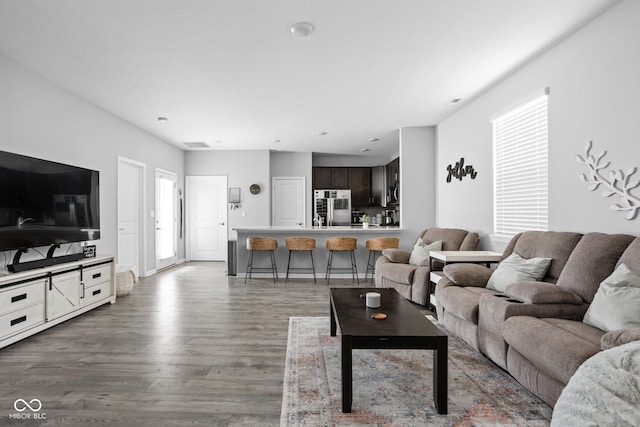 living area with visible vents and wood finished floors