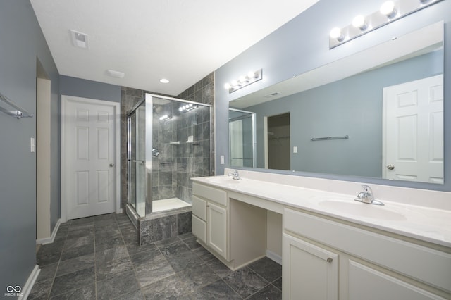 full bath featuring a closet, a sink, a shower stall, and double vanity