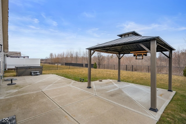 view of patio / terrace featuring a fenced backyard, a hot tub, and a gazebo