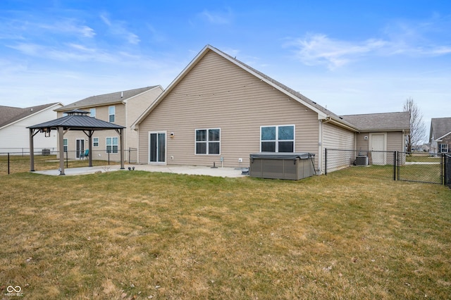 back of property featuring a gate, a patio area, a yard, and a gazebo