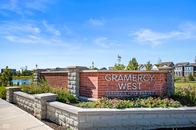 community sign with a water view, a residential view, and fence