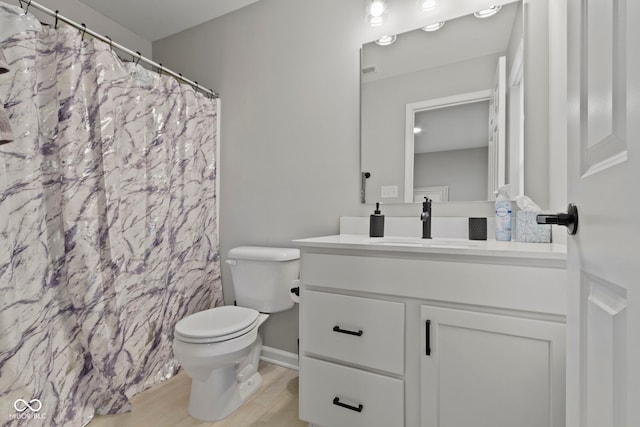 bathroom featuring vanity, a shower with shower curtain, wood finished floors, and toilet