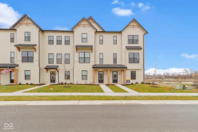 townhome / multi-family property featuring a front lawn and board and batten siding