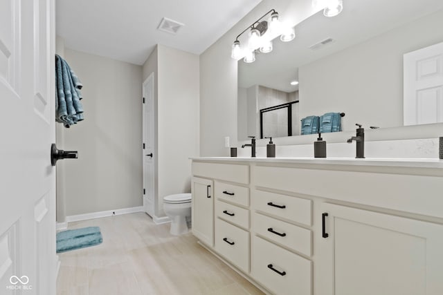 full bathroom with toilet, a shower stall, double vanity, and visible vents