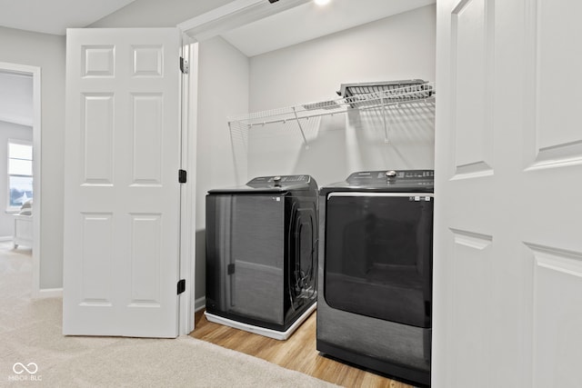 laundry area featuring laundry area, washing machine and dryer, light wood-style flooring, and baseboards