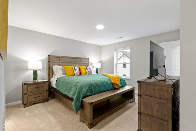 bedroom with light carpet and baseboards