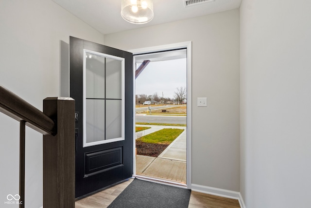 entryway with visible vents, baseboards, and wood finished floors