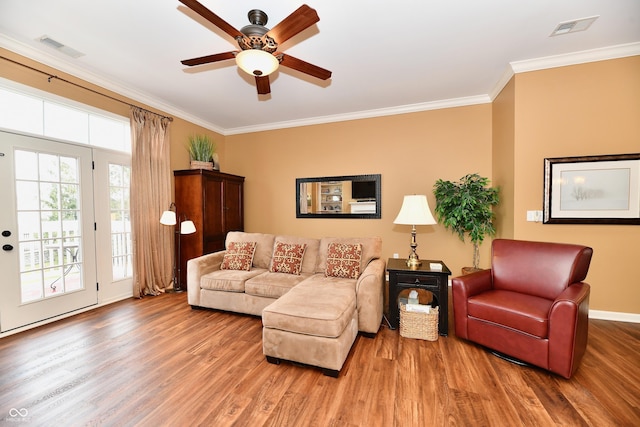 living room with visible vents, ornamental molding, a ceiling fan, and wood finished floors