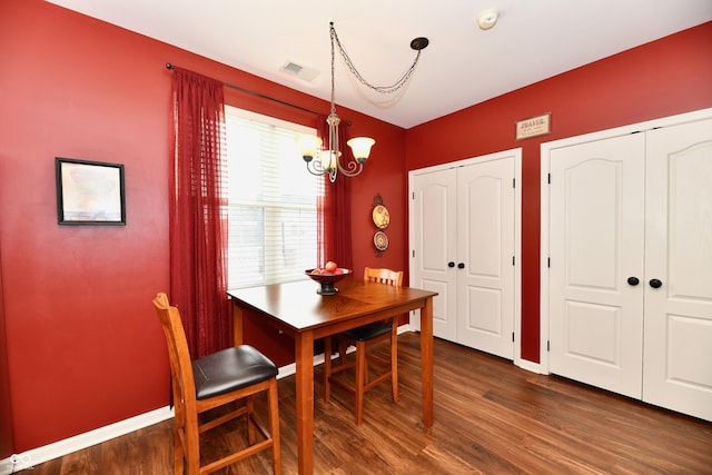 dining room featuring baseboards, wood finished floors, visible vents, and a chandelier