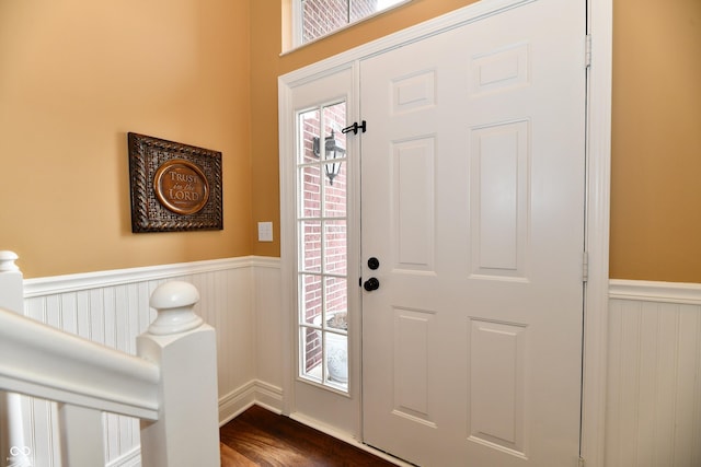 entryway with dark wood-style flooring and wainscoting