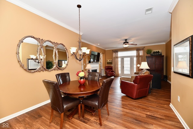 dining space featuring visible vents, ornamental molding, baseboards, and wood finished floors