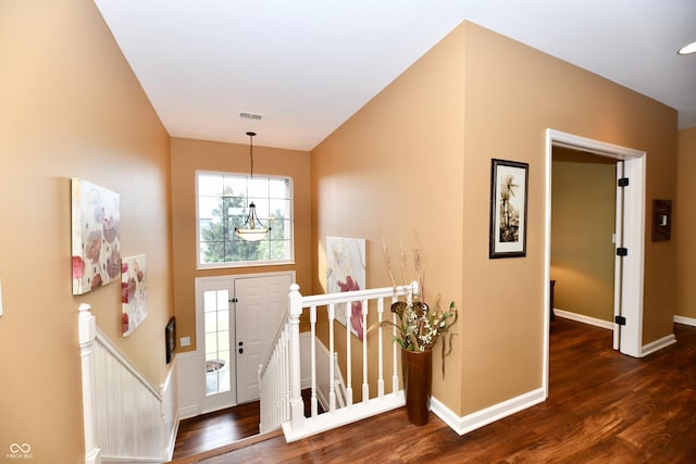 foyer entrance with wood finished floors, visible vents, and baseboards