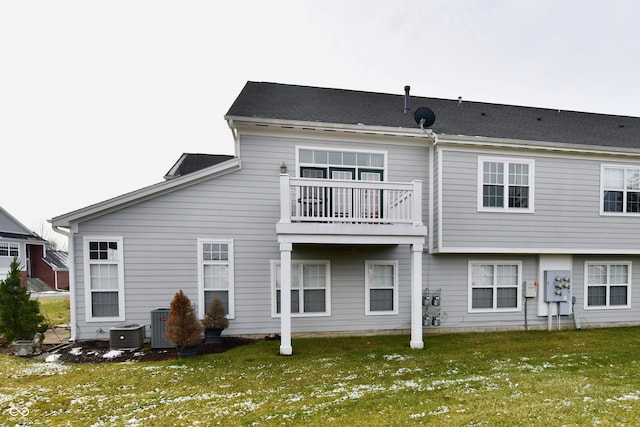 rear view of property with a lawn, cooling unit, and a balcony